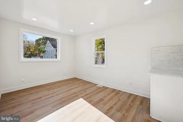 an empty room with wooden floor and window