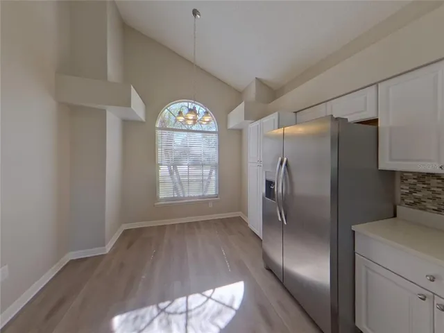 a view of a kitchen with a refrigerator cabinet and a ceiling fan