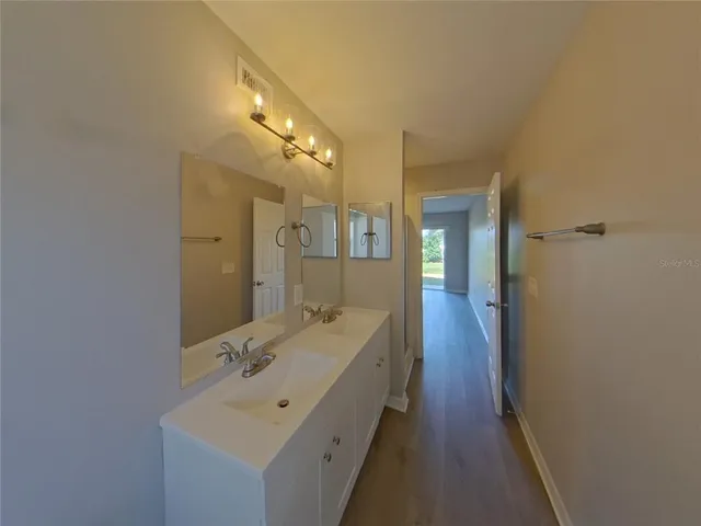 a spacious bathroom with a double vanity sink and mirror