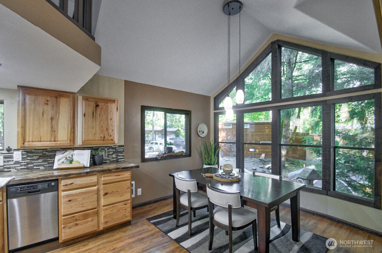 1546 Reservation Road Southeast, Unit 183 Olympia, WA 98513 - Photo 7 of 38 a kitchen with a table chairs and wooden floor