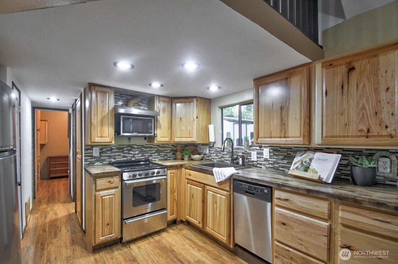1546 Reservation Road Southeast, Unit 183 Olympia, WA 98513 - Photo 10 of 38 a kitchen with a stove and white cabinets