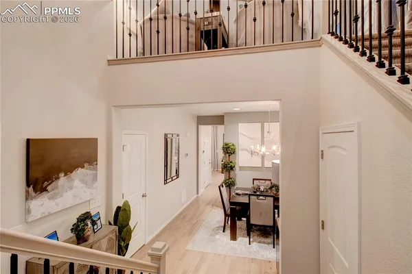 a view of a hallway with dining room and wooden floor