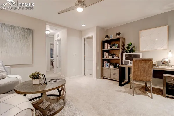 a living room with furniture a rug and a bookshelf