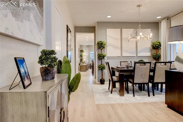 a dining room with furniture a potted plant and a chandelier