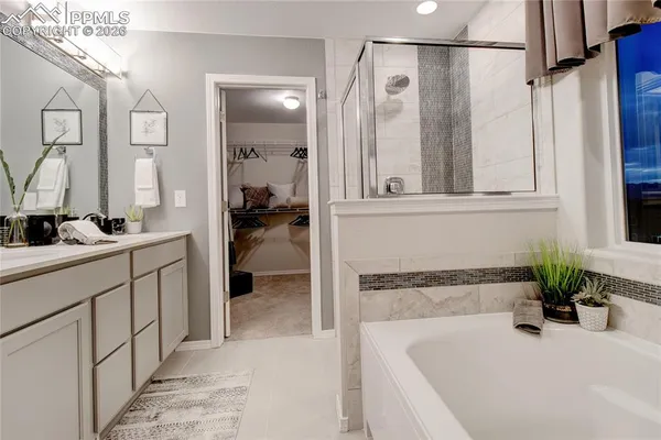 a bathroom with a tub a mirror and a shower