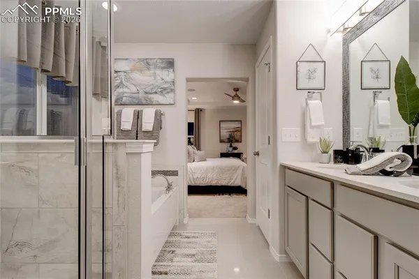 a en suite bathroom with a tub sink and mirror