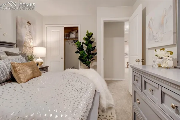 a bedroom with a large bed and a potted plant