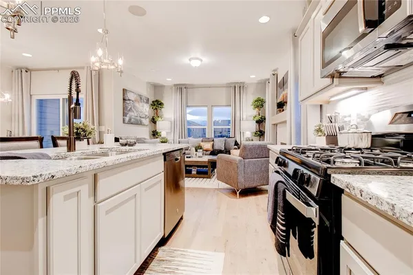 a large kitchen with stainless steel appliances granite countertop a lot of counter space and a sink