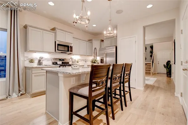 a kitchen with kitchen island granite countertop a center island a sink and a refrigerator