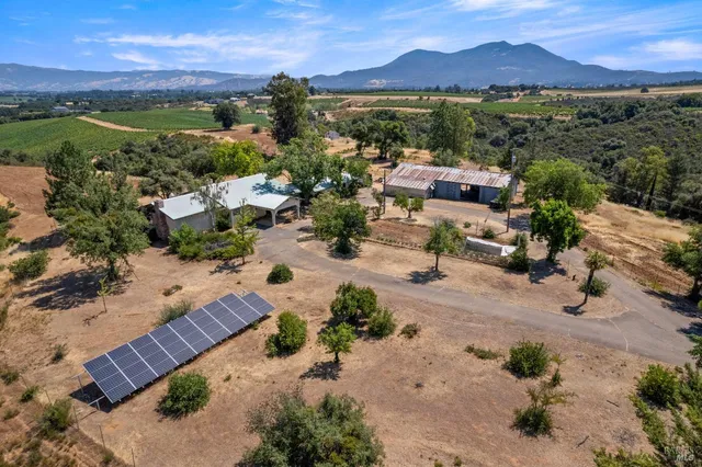an aerial view of a city with lots of residential buildings ocean and mountain view in back