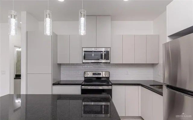 a kitchen with a refrigerator and a stove top oven