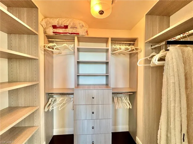 a view of walk in closet with empty racks