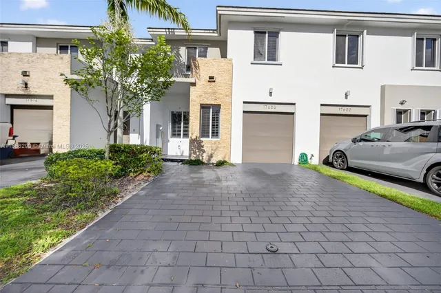 a front view of a house with a yard and a garage