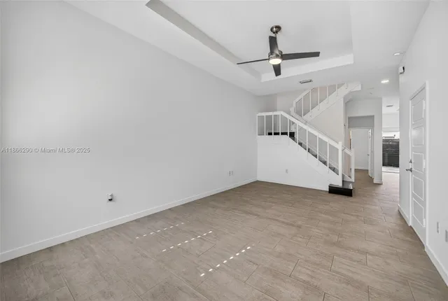 a view of a room with stairs and a ceiling fan