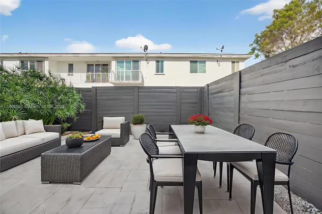 a backyard of a house with dining table and chairs