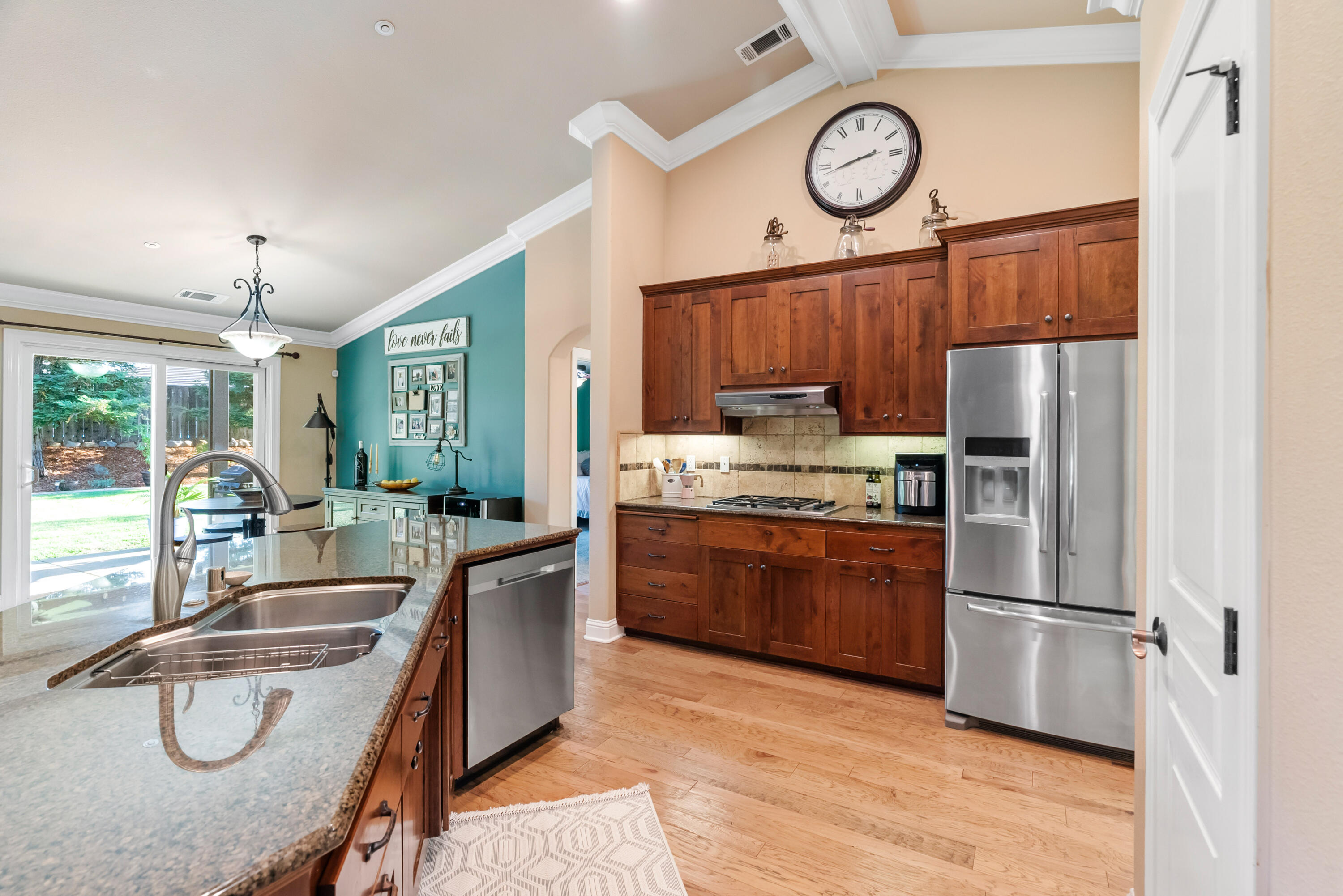3149 Laver Street Redding, CA 96002 - Photo 13 of 40 a kitchen with stainless steel appliances granite countertop a refrigerator a sink dishwasher a dining table and chairs with wooden floor
