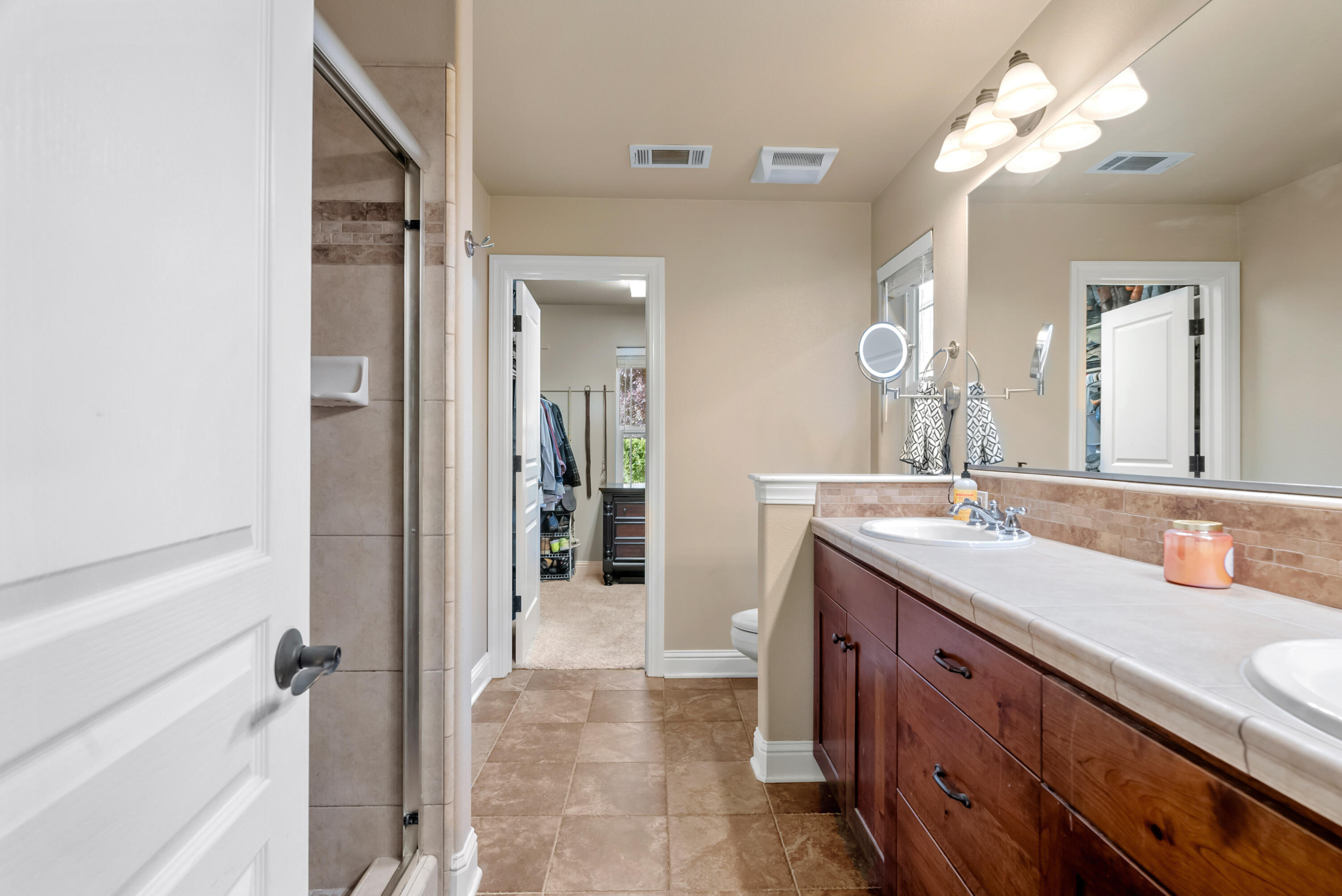 3149 Laver Street Redding, CA 96002 - Photo 21 of 40 a bathroom with a granite countertop sink a large mirror and a shower
