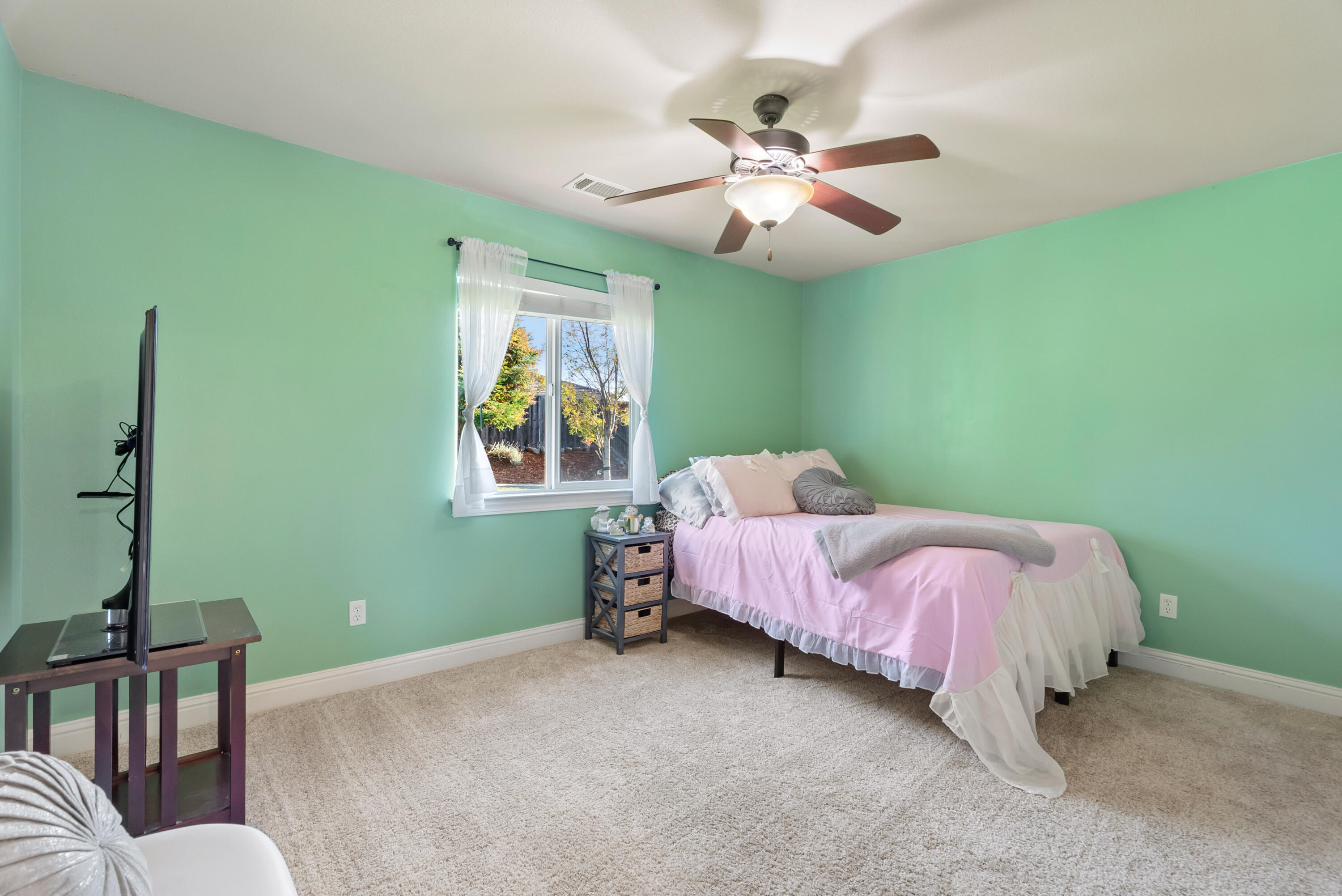 3149 Laver Street Redding, CA 96002 - Photo 25 of 40 a spacious bedroom with a bed and a chandelier