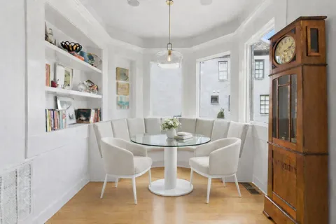 a view of a dining room with furniture a rug and wooden floor