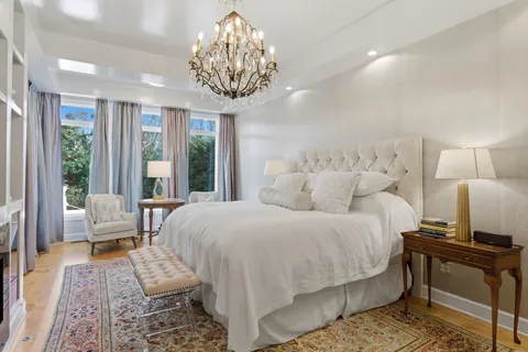 a spacious bedroom with a bed and a chandelier