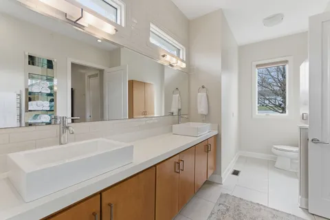 a bathroom with a sink a toilet and a mirror