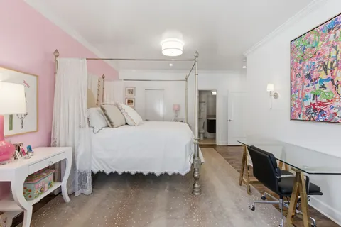 a spacious bedroom with a bed and a workspace