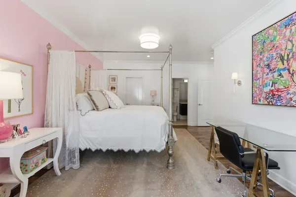 a spacious bedroom with a bed and a workspace