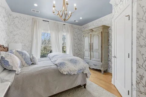 a spacious bedroom with a bed and a chandelier