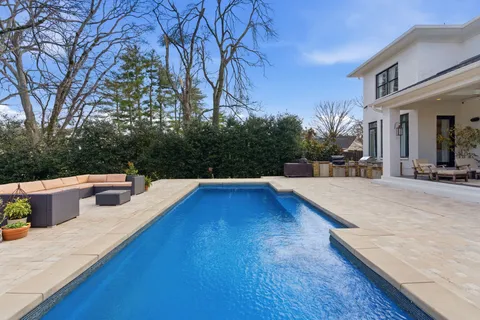 a view of a house with pool and sitting area