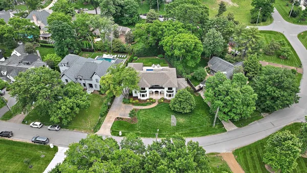 an aerial view of a house with a yard and large trees