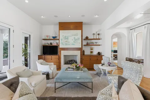 a living room with furniture fireplace and a large window