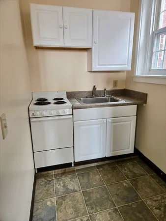 a kitchen with a stove top oven cabinets and a stove