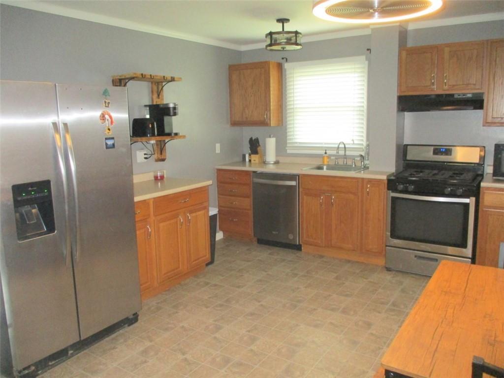 24 Russell Street Baden, PA 15005 - Photo 16 of 31 a kitchen with stainless steel appliances granite countertop a refrigerator a sink a stove and island