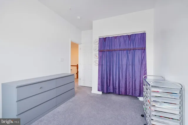 a view of an empty room with closet and a bathroom