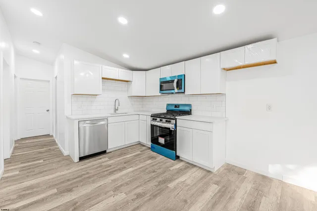 a kitchen with granite countertop white cabinets and white appliances