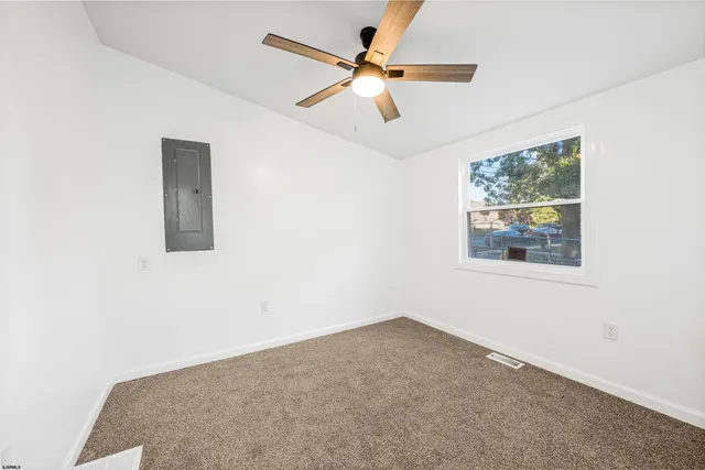 an empty room with windows and fan