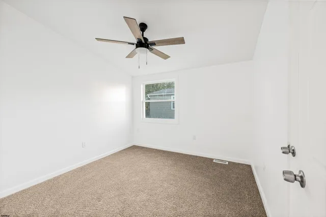 a view of a room with a ceiling fan and a window