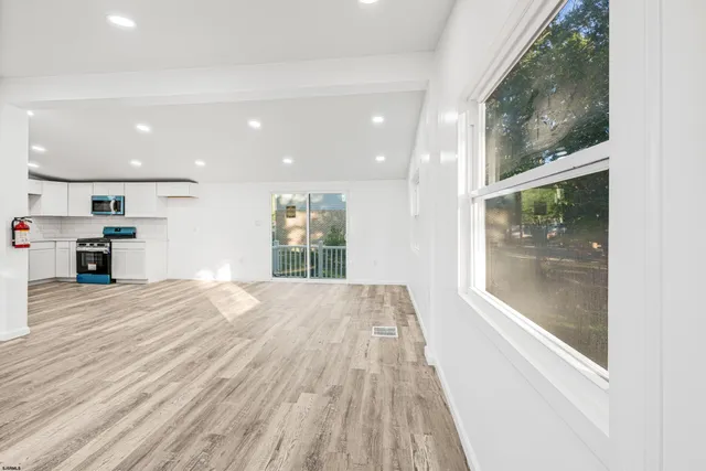 a view of a kitchen with kitchen island a window and a wooden floor