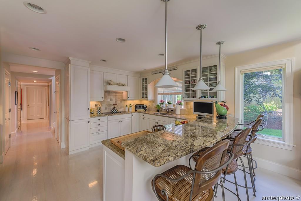 56 The Heights Mashpee, MA 02649 - Photo 5 of 16 a kitchen with stainless steel appliances granite countertop sink stove and white cabinets with wooden floor