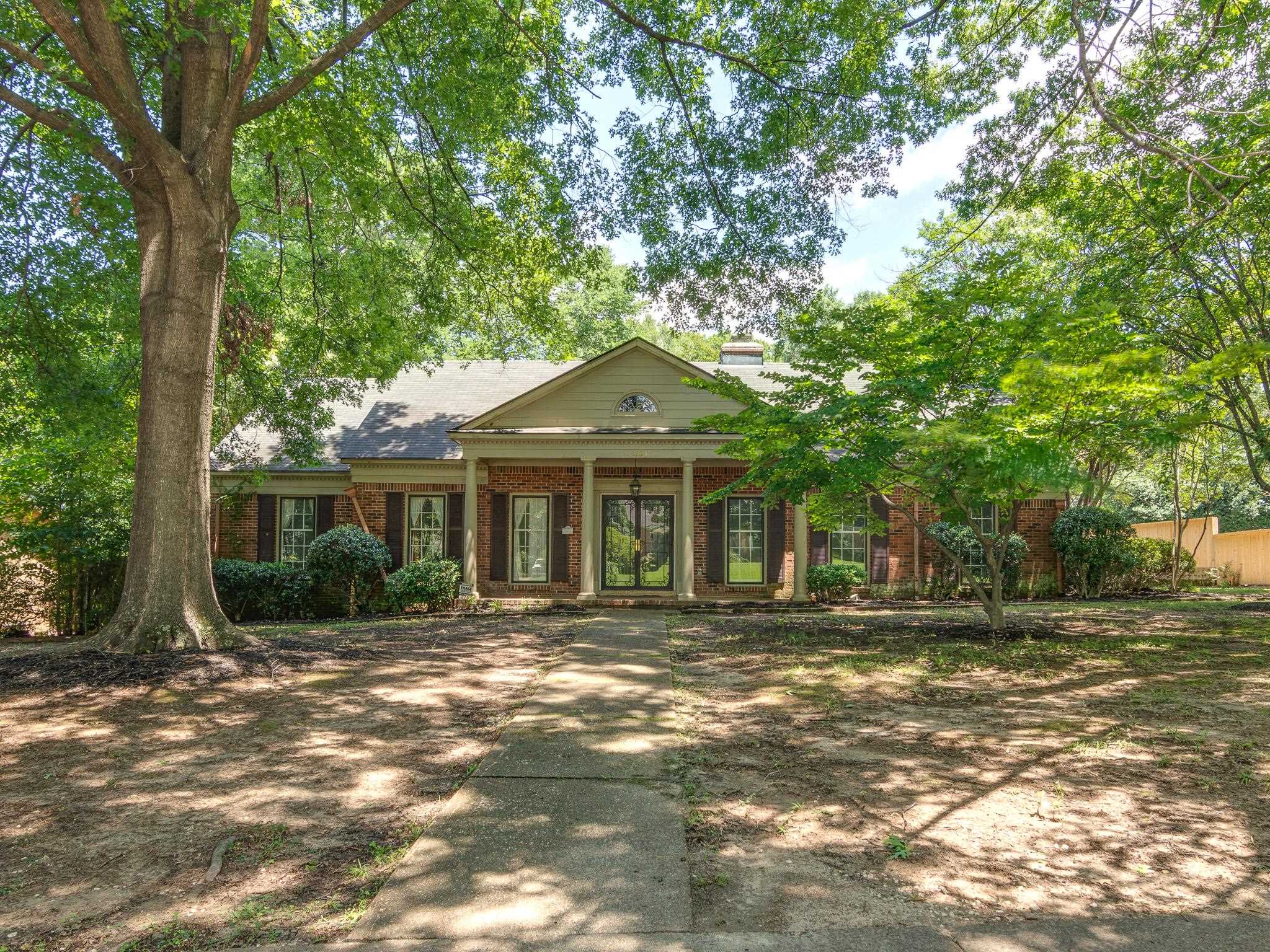 Brick facade residence featuring a covered entry with columns and pediment