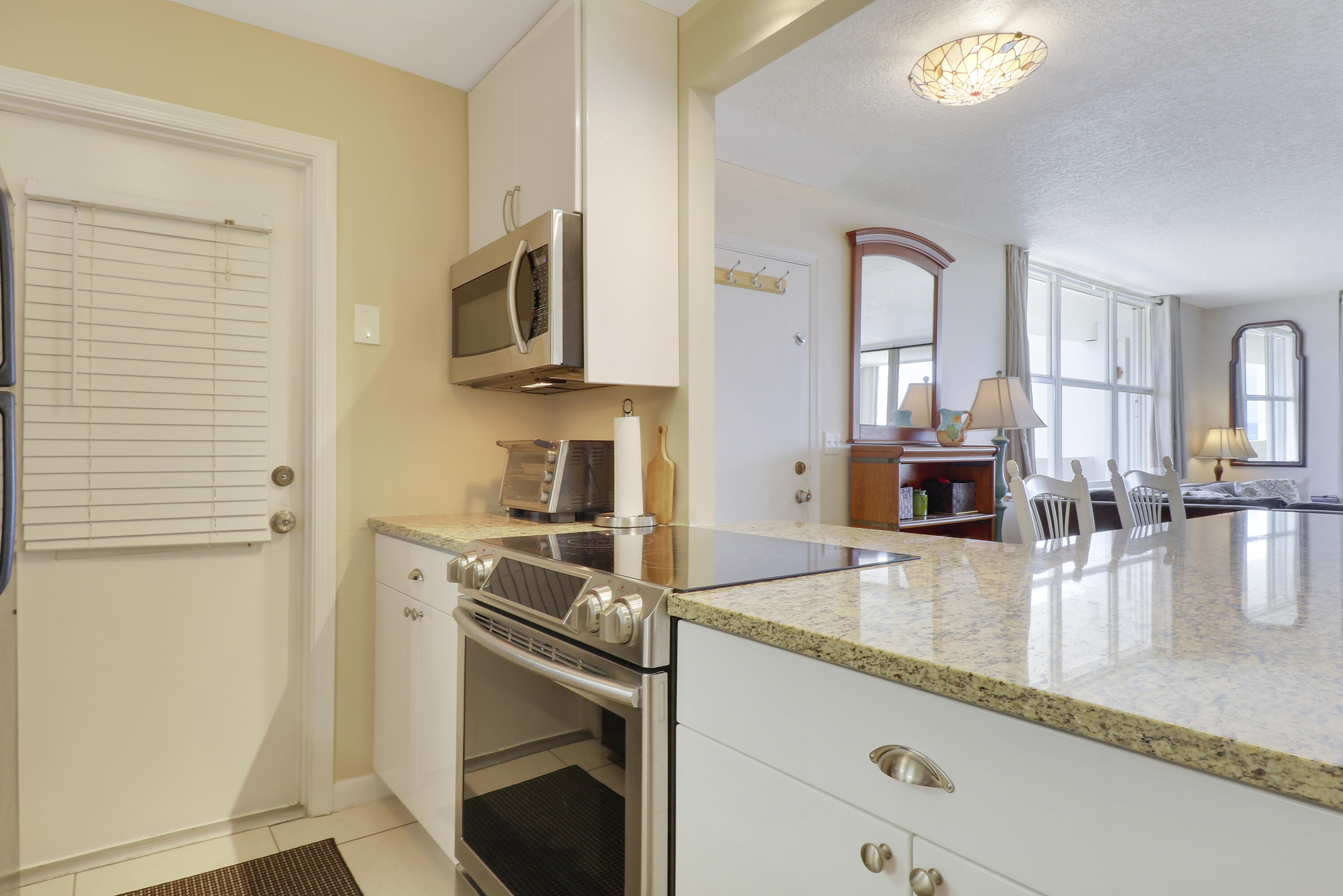 3640 North Ocean Drive, Unit 427 Singer Island, FL 33404 - Photo 11 of 43 a kitchen with stainless steel appliances granite countertop a stove a sink and a refrigerator