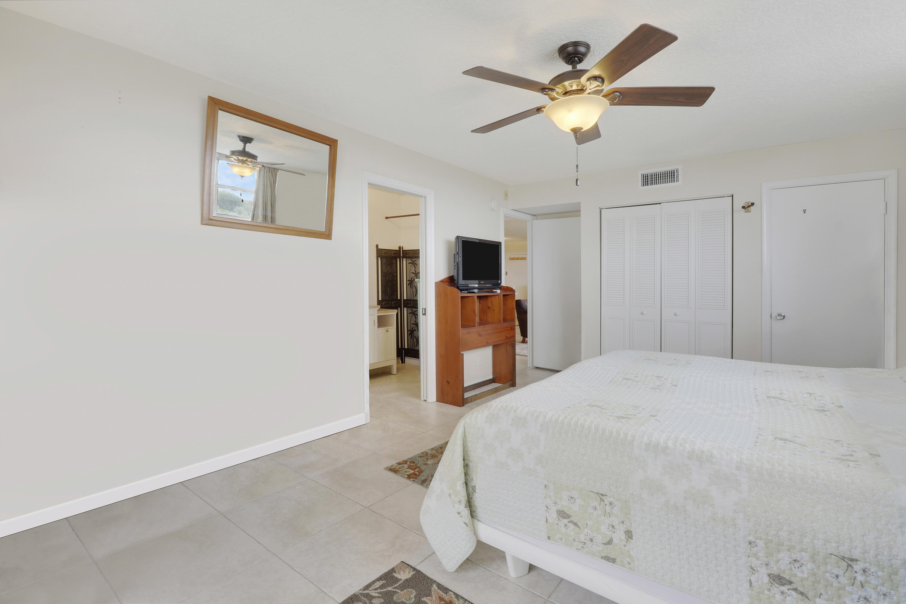 3640 North Ocean Drive, Unit 427 Singer Island, FL 33404 - Photo 19 of 43 a bed room with a bed and a ceiling fan