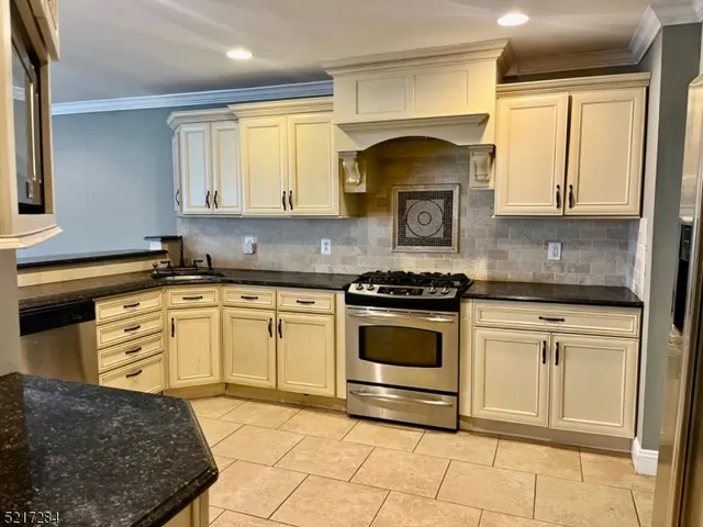 a kitchen with granite countertop a stove a sink and a microwave