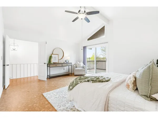 a bedroom with a bed next to a window with a chandelier
