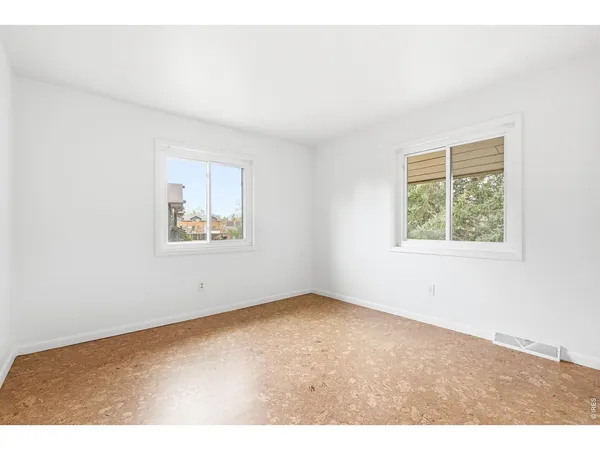 a view of an empty room with fireplace stairs and windows