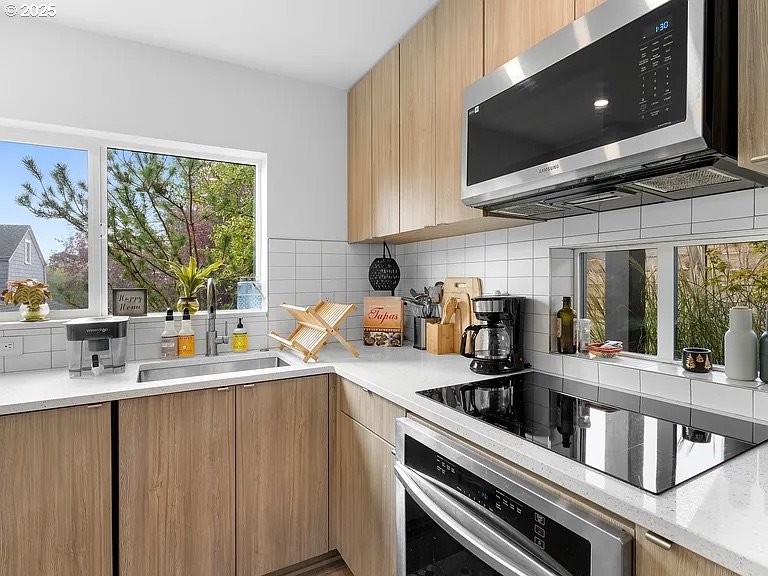 3590 Southwest Patton Road, Unit C Portland, OR 97221 - Photo 11 of 40 a kitchen with stainless steel appliances a sink a stove and a microwave