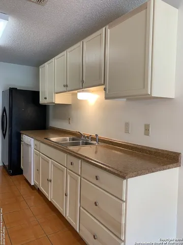a kitchen with granite countertop white cabinets and stainless steel appliances