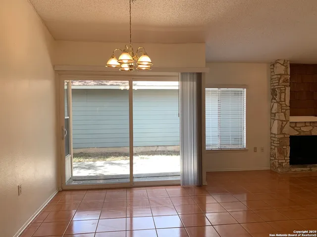 a view of a livingroom with a chandelier fan and windows