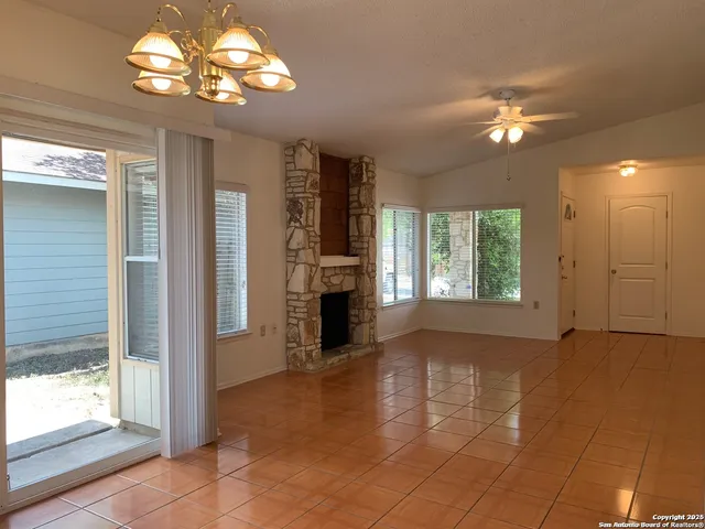 a view of a livingroom with a chandelier fan and windows