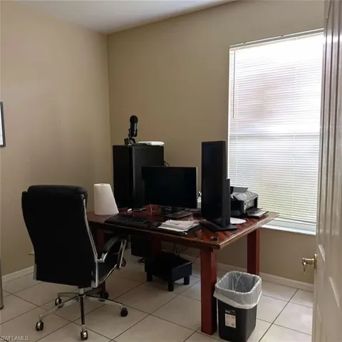 a view of a workspace with furniture and a window